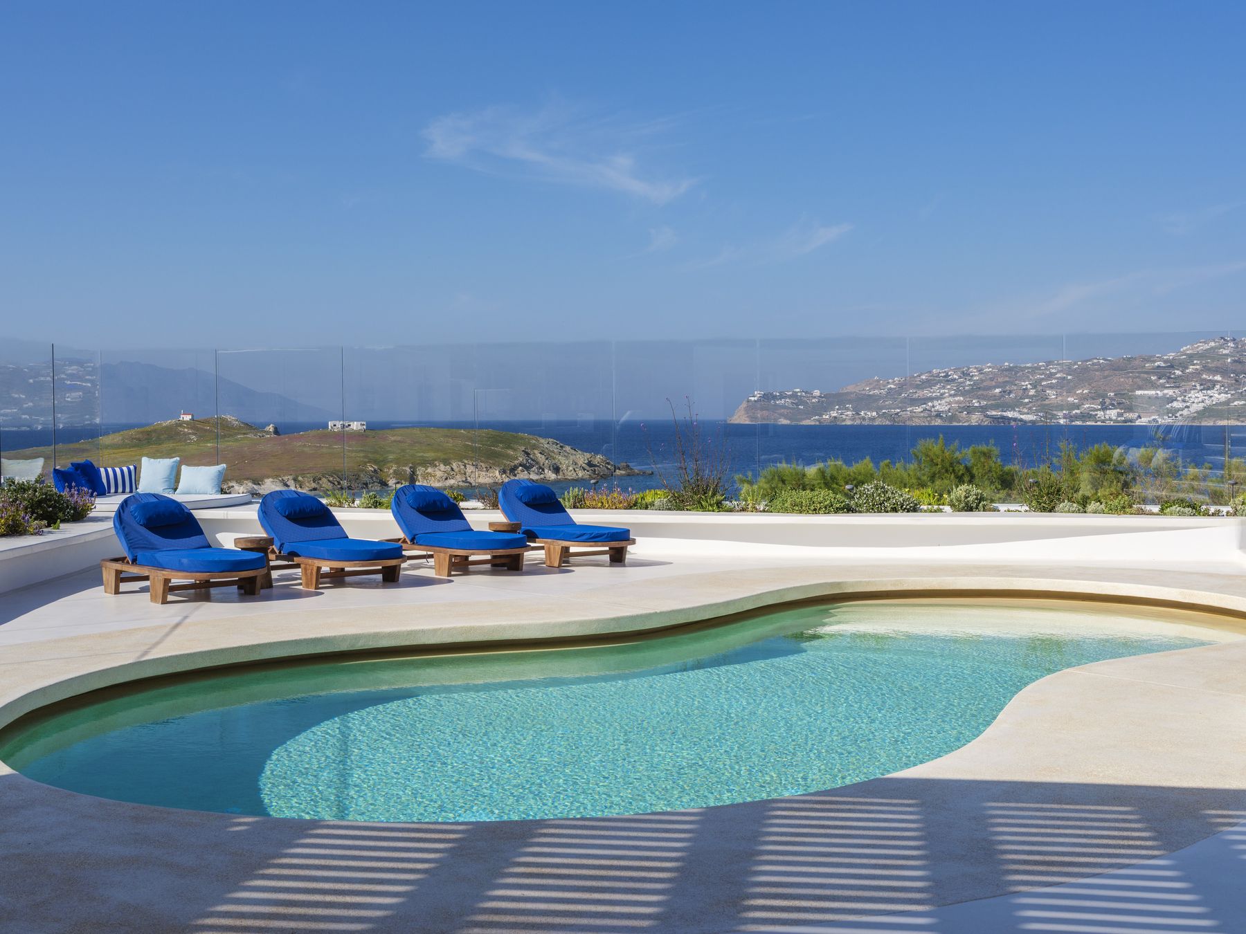 Pool and sun loungers with a view over the bay