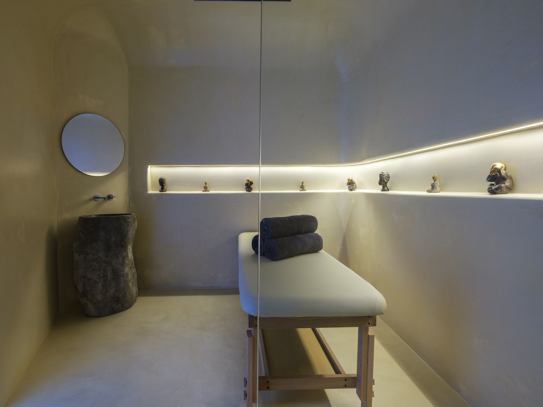 Massage room with massage table and stone basin